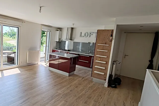 Séjour et cuisine ouverte d’un duplex donnant sur la verdure