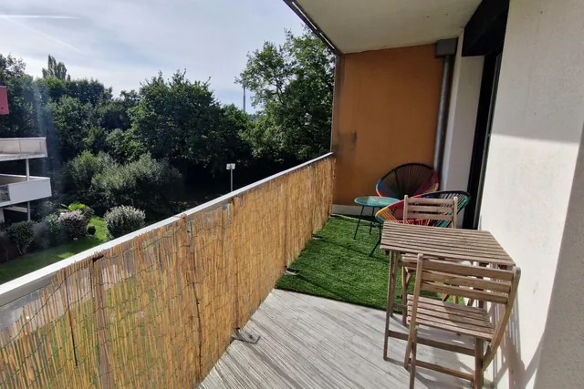 Balcon d’un appartement face à un jardin arboré